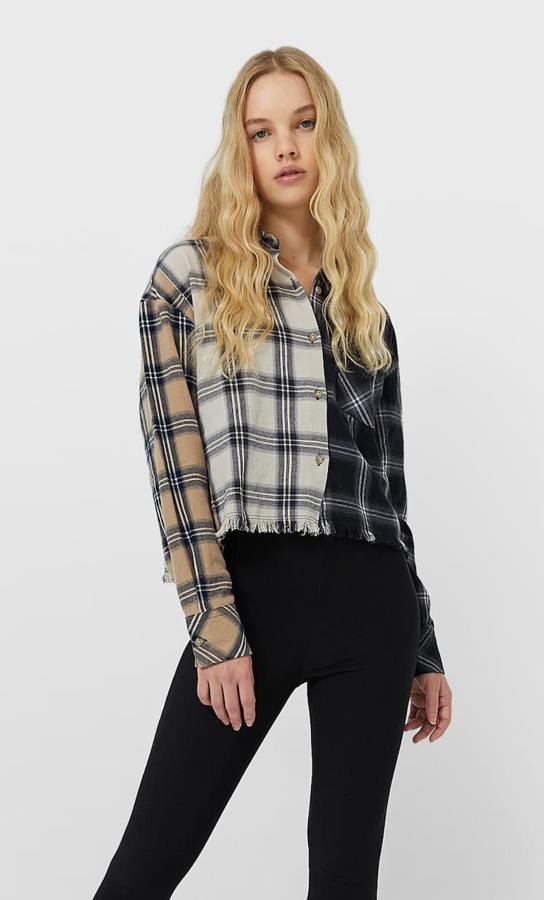 Con estampado cuadros en color negro y crudo, esta camisa corta de manga larga acabada en puños cuenta con bajo desfilado y tiene un precio de 15,99 euros.