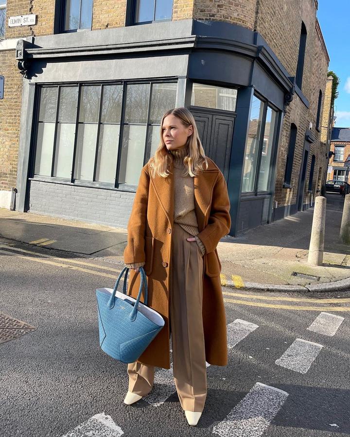 Abrigo largo de color camel + pantalón ancho con pinzas + bolso con piel grabada de color azul