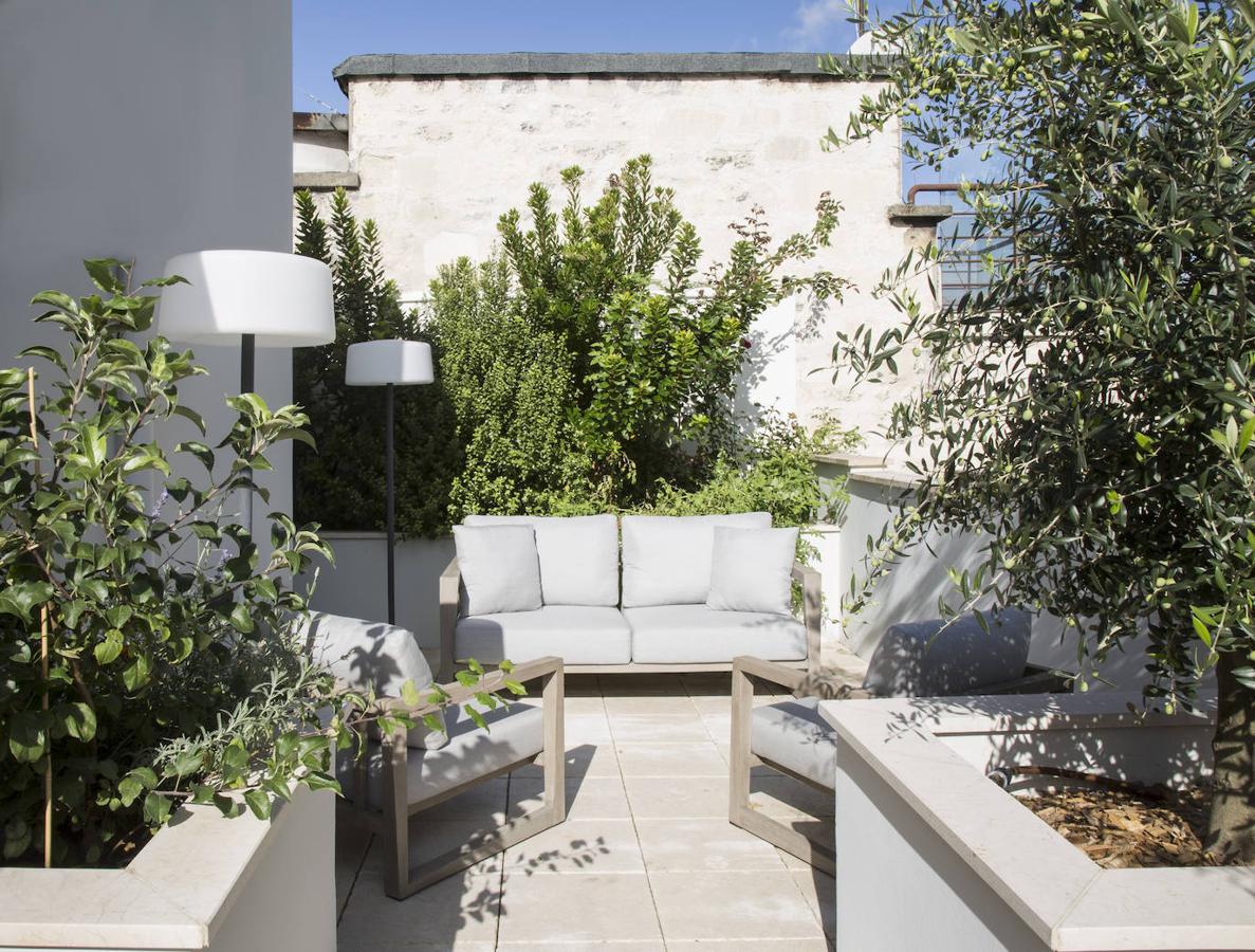 La terraza, que da a la fachada posterior, con sofás y lámparas de Les Jardíns.