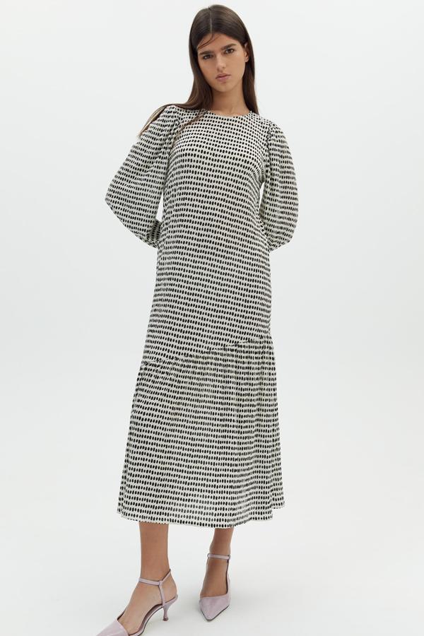 Disponible en varios colores, este vestido en tejido con textura en blanco y negro cuenta con manga abullonada y volante en el bajo. Es de Sfera y tiene un precio de 25,99 euros.