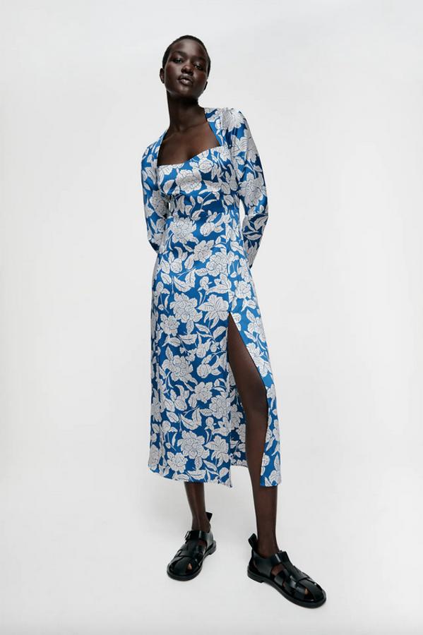 Diseño midi para este vestido de Zara con escote amplio cuadrado, detalle de corte en cintura, bajo acabado en evasé y abertura en un lateral. En fondo azul con estampado de flores blancas, cuesta 39,95 euros y está disponible entre las tallas XS y XL.