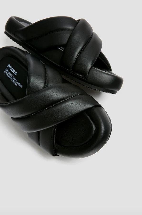 Diseño de tiras acolchadas cruzadas para estas sandalias en negro con suela de tres centímetros que cuestan 25,99 euros y podemos encontrarlas en Pull&Bear entre los números 35 y 41.