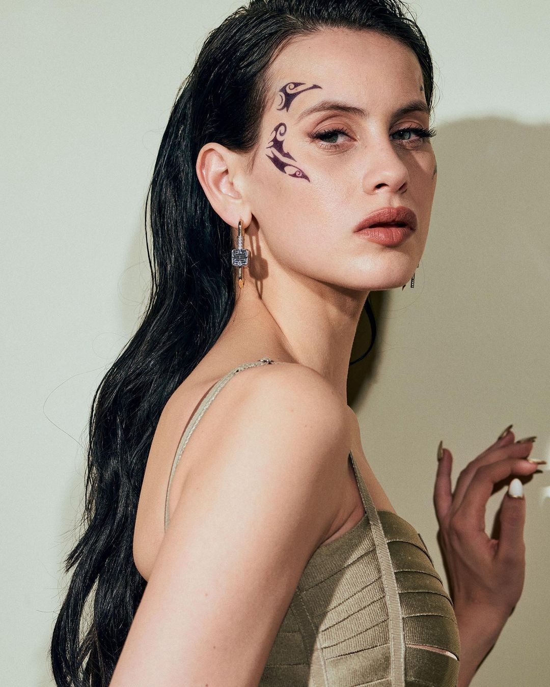 Milena Smit, nominada a los Premios Goya 2021 por su papel protagonista en 'No matarás', debuta en la fiesta del cine con una melena XXL de acabado wet, un maquillaje nude super favorecedor y natural, y un atrevido tatuaje en el lateral del rostro.