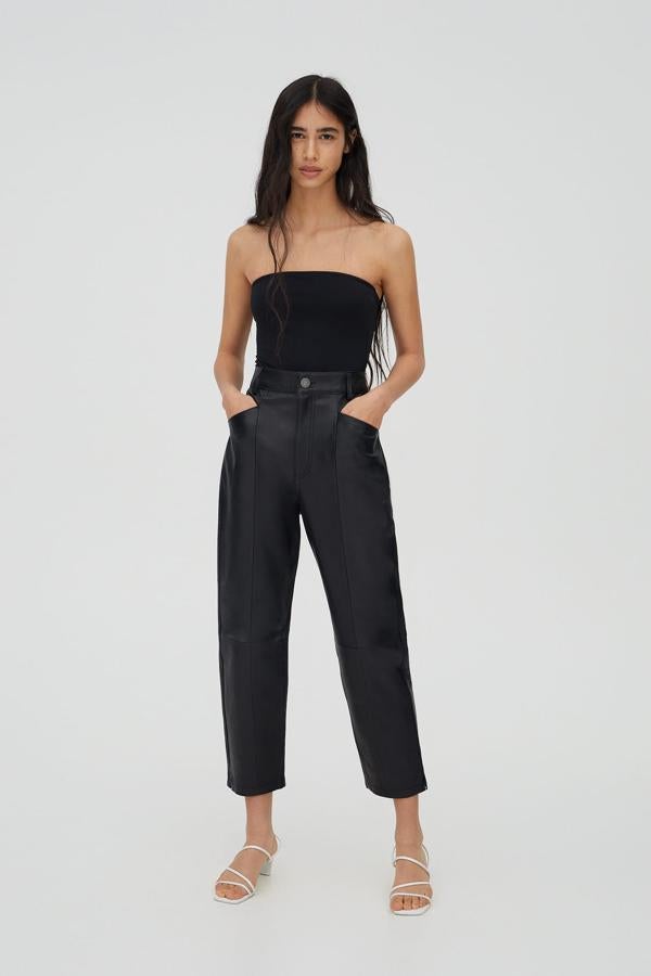 El mismo conjunto pero en color negro: body de canalé, pantalón de corte "mom" y sandalias de tacón bajo.