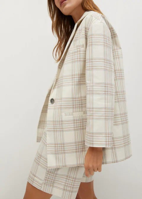 Blazer de cuadros con tejido de algodón en color blanco de Mango con bermuda a juego para un lookazo de otro nivel. (39,99 euros).