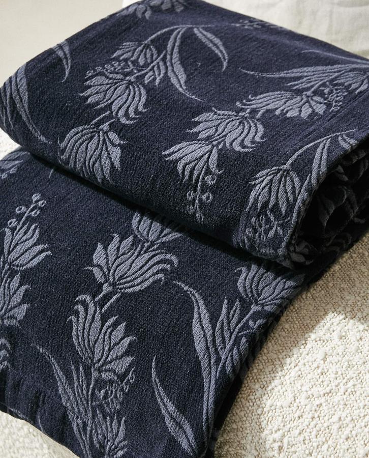 En color azul oscuro con flores en azul, esta manta mide 140x190 centímetros y tiene un precio de 59,99 euros.