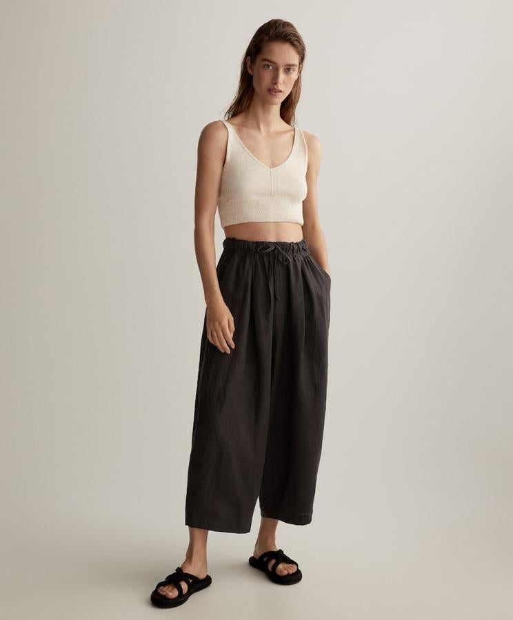 Pantalón ancho 100% lino de Oysho: 29,99 euros. Disponible en color pizarra y beige, con cinturilla elástica y largo tobillero.