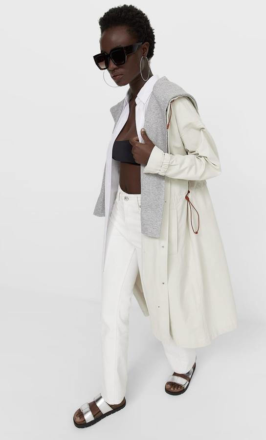 En color vainilla, este trench de cuello subido y capucha cuenta con manga larga acabada en puño y cierre con botonadura a presión. Tiene un precio de 39,99 euros.