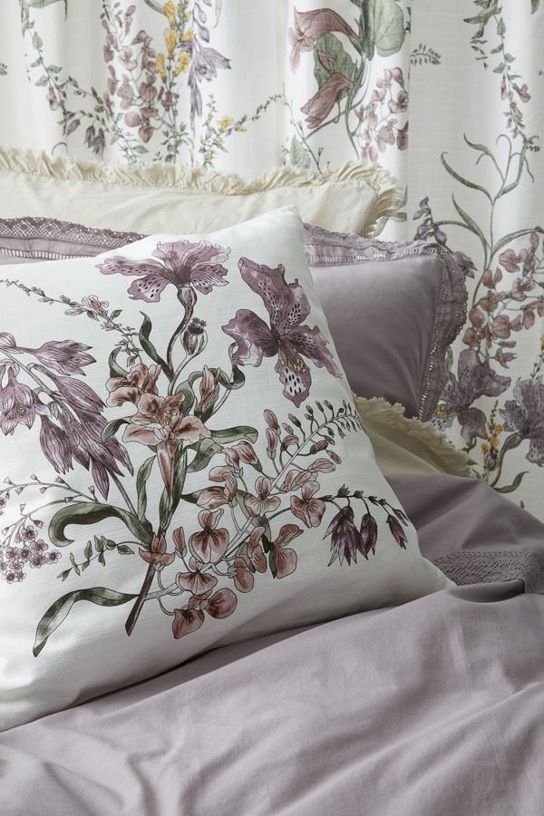 Este cojín con estampado de flores en tonos malva cuesta 9.99 euros en H&M Home.
