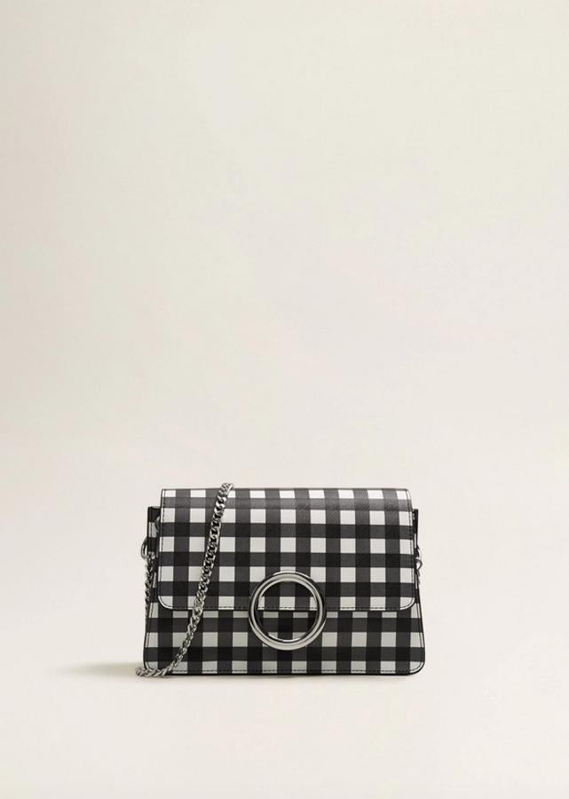 Esta bandolera de Mango con efecto safiano y estampado de cuadro Vichy en blanco y negro viene con doble compartimento interior y asa de hombro de cadena. Con cierre metálico de imán y detalle metalizado en la solapa, podemos comprarlo por 25,99 euros. La firma ha lanzado un neceser y un tarjetero a juego.