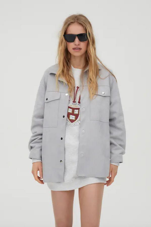 En Pull & Bear han apostado por esta sobrecamisa en color gris con cuello clásico, mangas largas y cierre frontal de botones metalizados, con bolsillos de plastrón en la pechera. Tiene un precio de 25,99 euros y está disponible entre las tallas XS y XL.