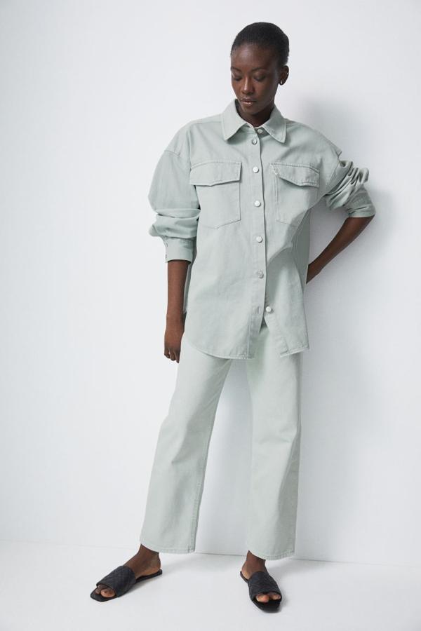 En H&M también han apostado por el verde menta para una sobrecamisa en denim de algodón lavado grueso con cuello clásico y cierre de botones frontal. Con hombros marcadamente caídos, puños abotonados y bolsillos de plastrón en la pechera con solapa, viene con bajo redondeado asimétrico y cuesta 29,99 euros. Podemos encontrarla entre las tallas XS y XXL.