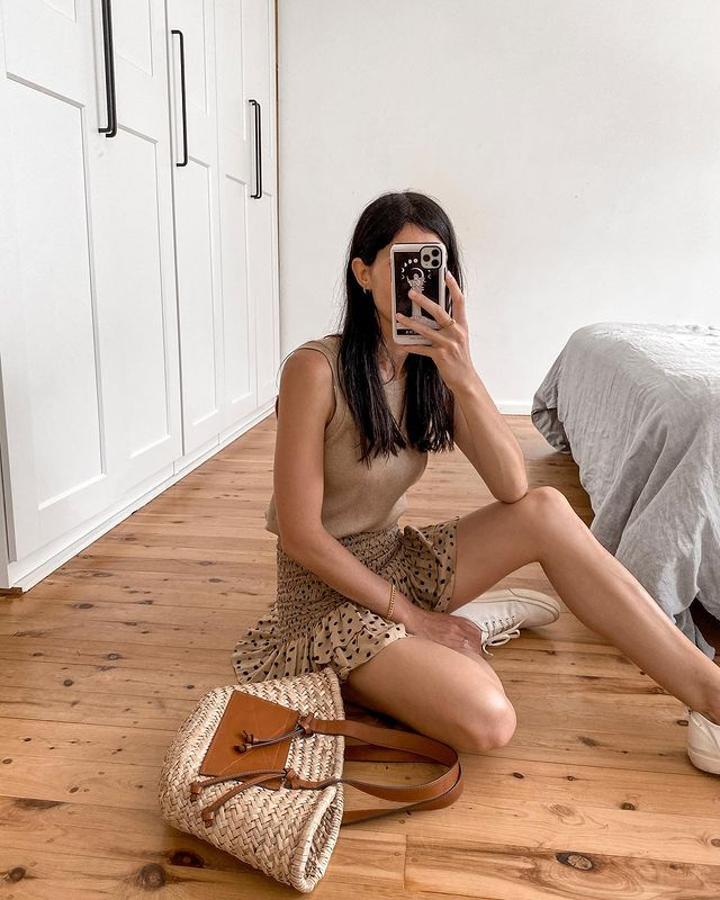 Un look fresco e informal con minifalda estampada con lunares y zapatillas blancas.