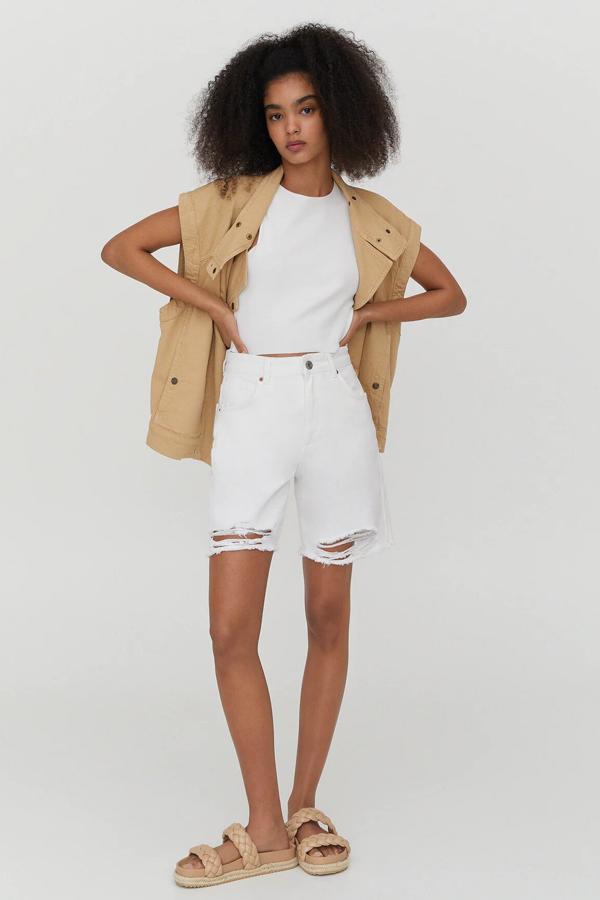 Confeccionada con algodón reciclado, esta bermuda larga con detalle de rotos y bajo deshilachado es de Pull & Bear y tiene un precio de 25,99 euros.
