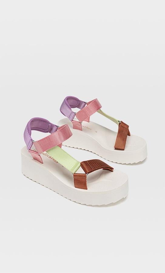Con suela fatform en color crudo y tiras de varios colores, esta sandalia cuenta con cierre mediante tira adherente en la parte delantera y tienen un precio de 25,99 euros.
