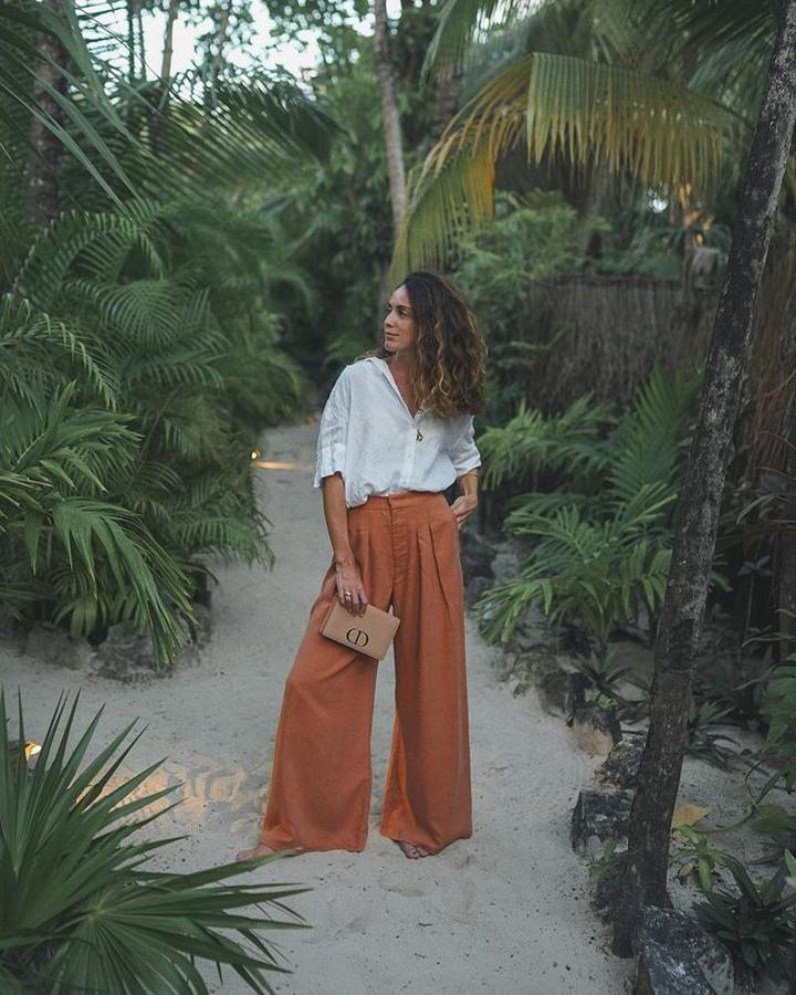 Camisa blanca + pantalones naranja "wide leg" + bolso de mano