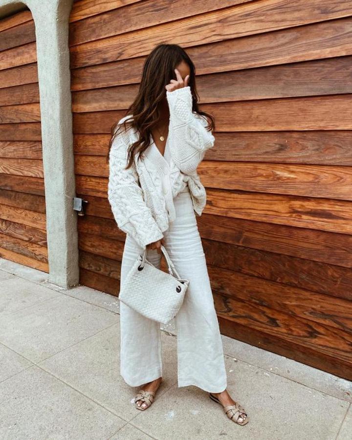 Con chaqueta de punto y sandalias planas en color arena (Sincerely Jules)