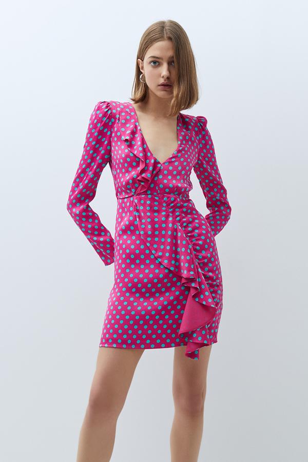 De manga larga y con escote de pico, este vestido fucsia con lunares en azul y volante en la parte delantera tiene un precio de 49,99 euros.