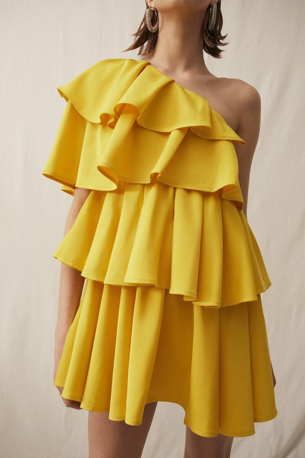 En color amarillo, este vestido corto asimétrico y con grandes volantes tiene un precio de 59,99 euros.