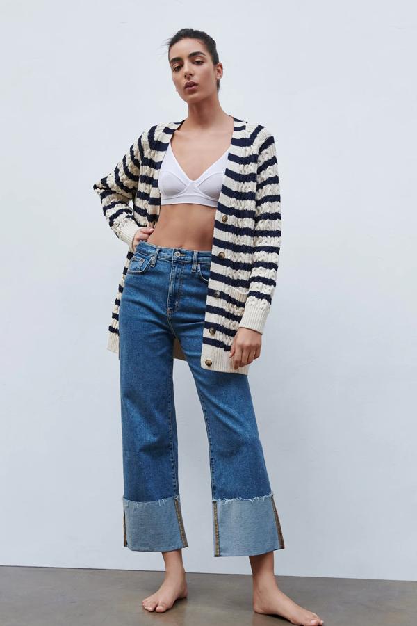 Esta chaqueta larga de punto en color crudo con rayas en negro cuenta con bolsillos delanteros de plastrón y cierre frontal con botones. Es de Zara y tiene un precio de 29,95 euros.