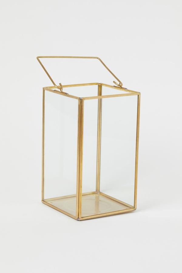 Este portavelas de vidrio y metal en color dorado está indicado para velas gruesas y tiene unas medidas de 12x20 centímetros.