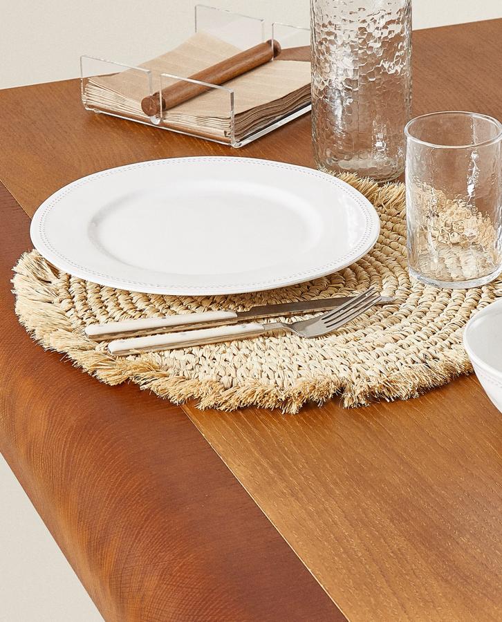 Este mantel individual redondo en rafia trenzada con contorno de flecos tiene un precio de 12,99 euros.