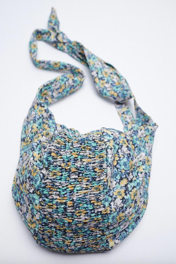 Disponible con estampado de flores en tonos turquesa, lila y mostaza o con estampado de cuadro Vichy en esmeralda y blanco, este bolso de hombro de Zara viene con detalle fruncido en el centro del cuerpo, asa de hombro ajustable con detalle de nudo y cierre mediante cremallera superior. Tiene un precio de 25,95 euros.