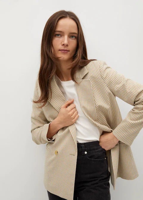 Que no falte una blazer de cuadros vichy en tu armario. Es pura tendencia y viene fenomenal tanto para ir a la oficina como para salir a tomar algo. Nos encanta esta en color ocre de Mango. (49,99 euros).