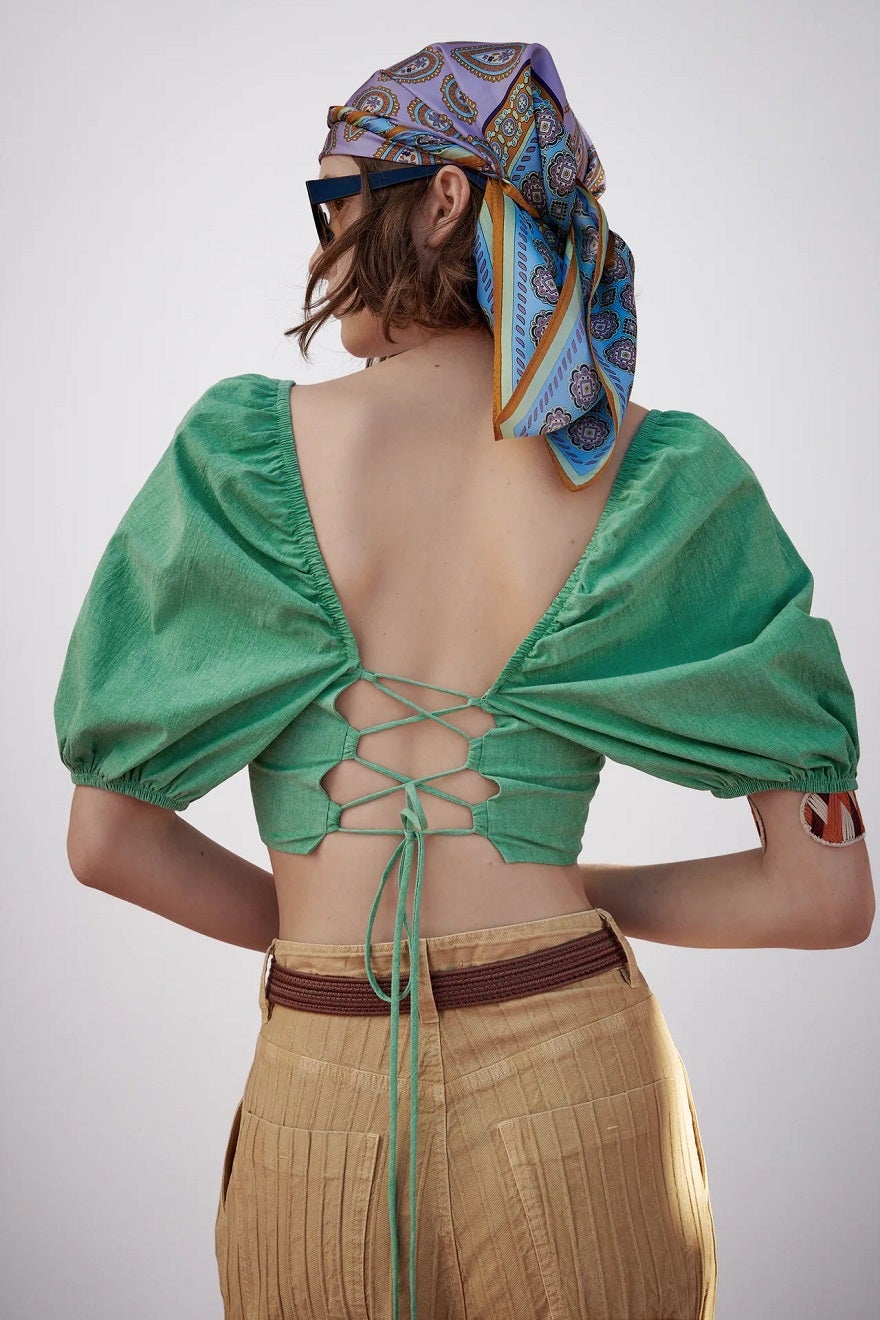 Top croppes en color verde con escote delantero recto y escote abierto en la espalda con cierre de tiras cruzadas y mangas abullonadas. Un best seller de la nueva colección de Zara que ya está agotándose. (22,95 euros).