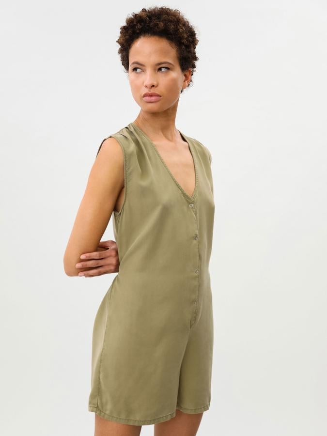 Sin mangas y con fruncido en los hombros, este mono vaquero corto disponible en azul y verde caqui cuenta con cierre delantero mediante botones a presión y lazada trasera. Tiene un precio de 12,99 euros.