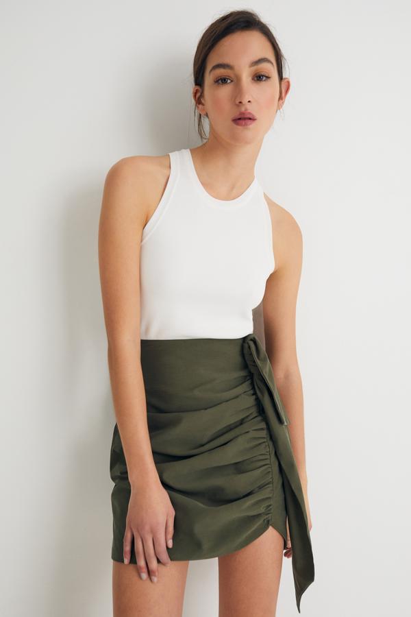 En color verde, esta falda mini con fruncido en un lateral tiene un precio de 19,99 euros.