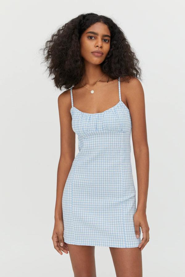 Disponible en azul o en verde, este vestido mini con estampado de cuadros vichy cuenta con tirantes finos y detalle de frunces en el pecho. Tiene un precio de 19,99 euros.