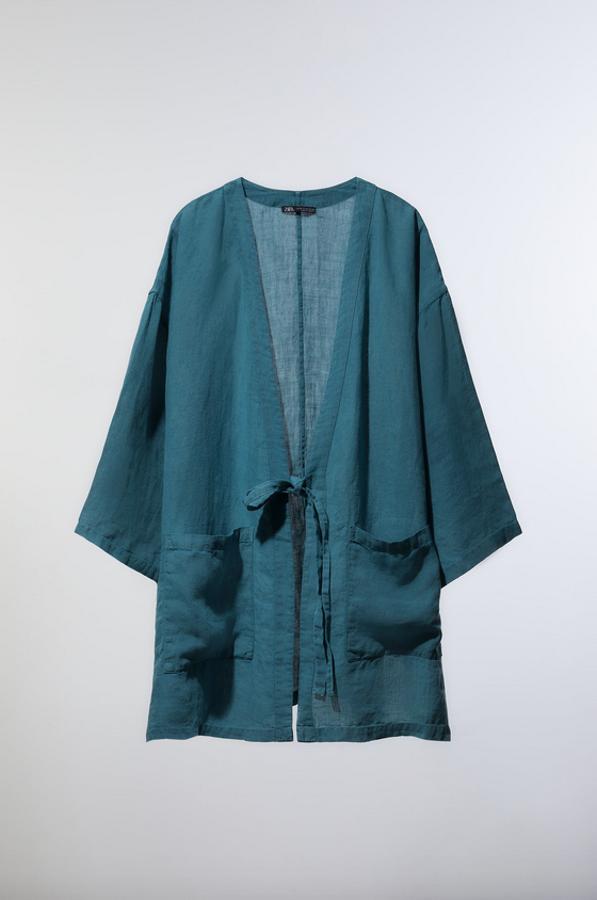En color azul confeccionado en tejido 100% lino, este kimono viene con escote de pico cruzado y manga amplia por debajo del codo. Con bolsillos de plastrón en el frontal, bajo con aberturas laterales y cierre de lazada en el mismo tejido, cuesta 49,95 euros y solo queda en las tallas S y M.