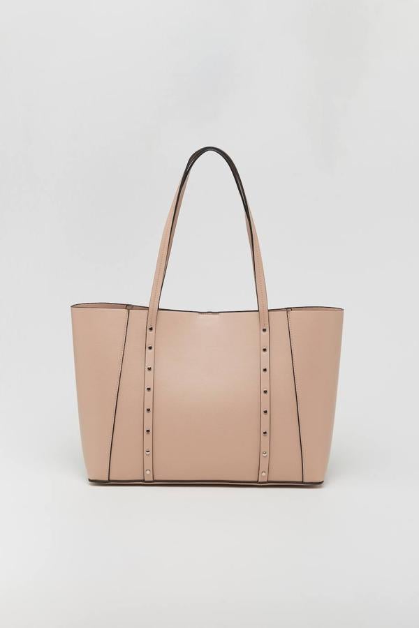 El aplique de tachuelas convierte a este shopper con doble asa al hombro en nuestro favorito de la lista. Además de ser muy amplio, tiene un pequeño bolsillo en el interior. Está disponible en dos colores: beige o marrón. Su precio es de 17,99 €.