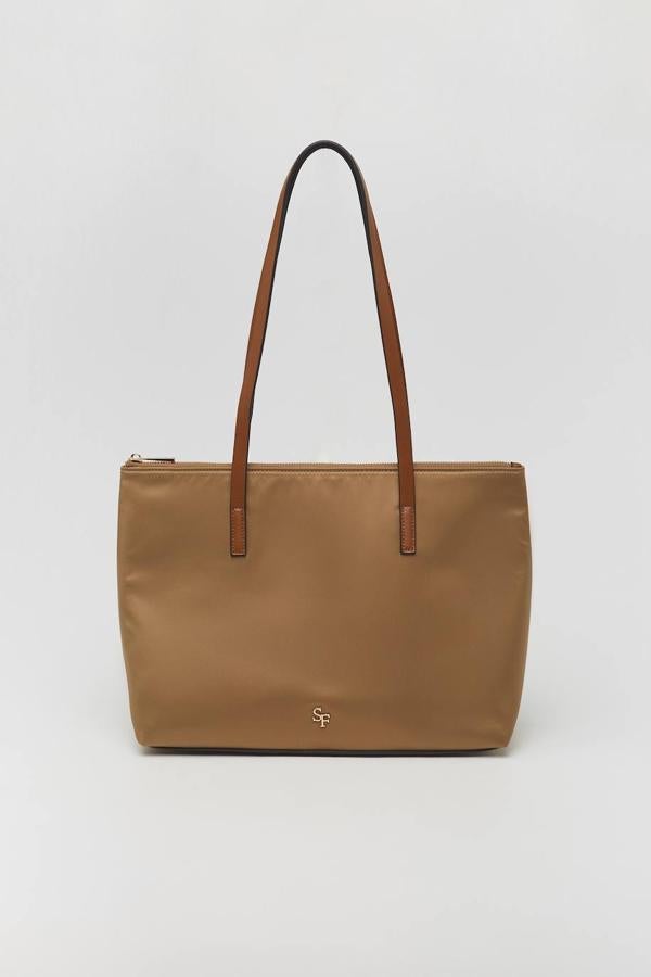 Este shopper técnico de color camel es perfecto para completar un look urbano con un toque de estilo safari. Su cierre es mediante cremallera, lo que lo hace especialmente seguro. Puede ser tuyo por 17,99 €.