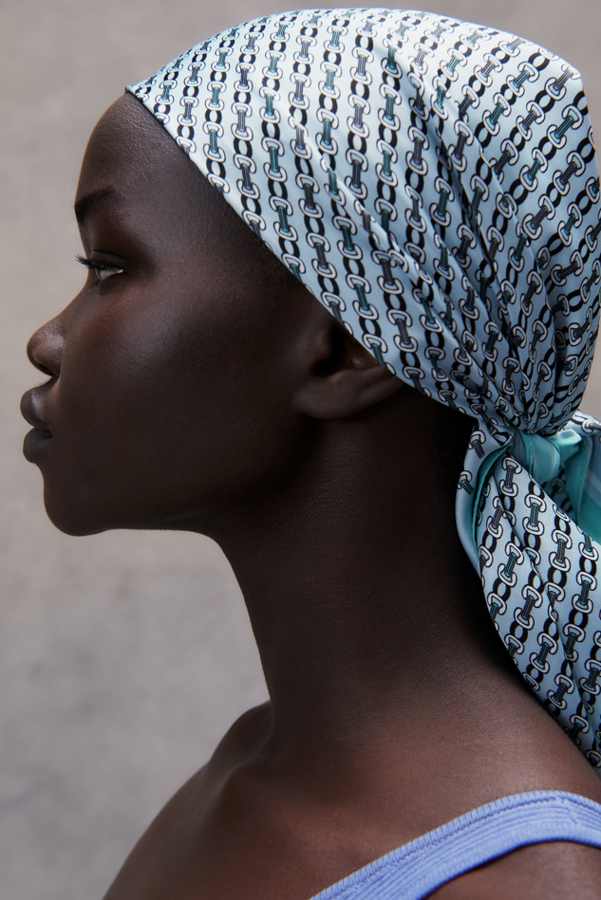 Pañuelos hay muchos, por fortuna. Son el accesorio estrella de la temporada. Vistos todos, nos quedamos con este preciosísimo pañuelo azul cielo de Zara, con una combinación de color que favorece muchísimo a todas (cuanto más bronceadas, mejor) y un 'print' de cadenas retro fastuoso. Mide 70x70 centímetros, tiene un acabado satinado y cuesta, en Zara, 9,95 euros.