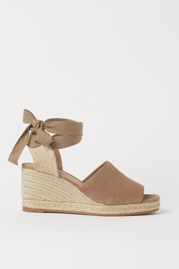 Estas alpargatas de ante con tiras y cuña en yute trenzado tienen una altura de ocho centímetros y un precio de 49,99 euros. Son de H&M.
