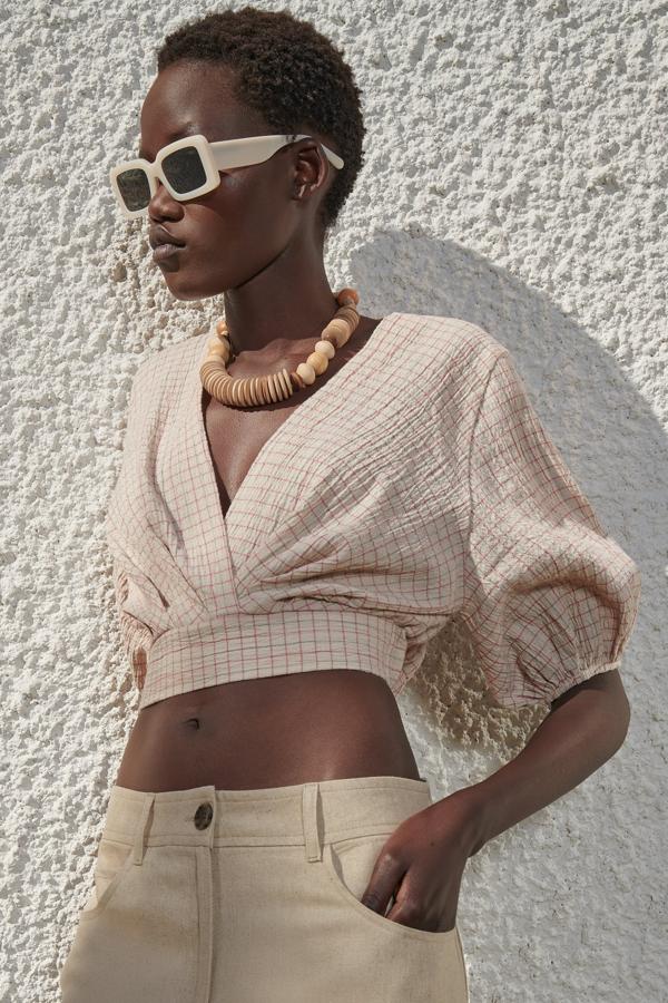 Con estampado de cuadros en tonos tierra, este top con manga corta abullonada acabada en elástico y escote cruzado tiene un precio de 25,95 euros.