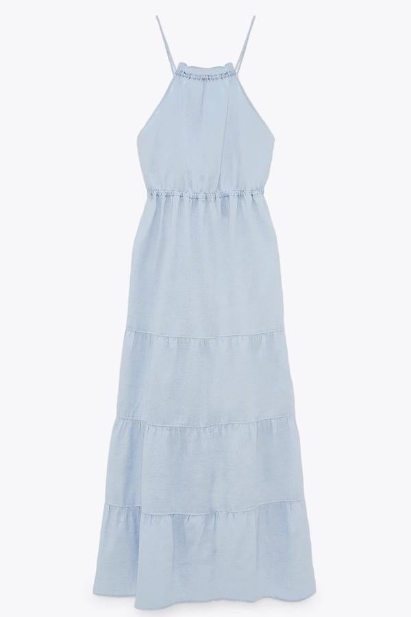 En color azul claro, este vestido midi confeccionado en tejido en mezcla de lino y algodón cuenta con cuello halter con volante y tirantes finos cruzados en la espalda. Tiene un precio de 39,95 euros.