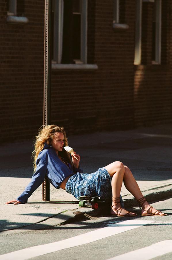 De tiro alto, con detalle de nudo y abertura en delantero, esta falda midi confeccionada en tejido con textura y estampado de flores blancas sobre fondo azul pato tiene un precio de 25,95 euros y está disponible entre las tallas XS y XL.