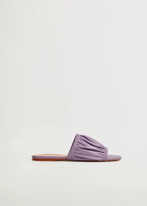 Sandalias planas en color lila con tira fruncida y ancha en el empeine. También disponibles en color crudo. (29,99 euros).