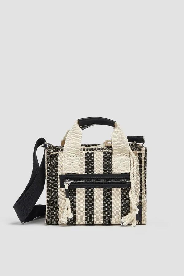 En beige y negro, este bolso bandolera de tela y tamaño mini cuenta con un bolsillo en la parte delantera y dos asas, una de mano y una de hombro ajustable y extraíble. Tiene un precio de 17,99 euros.