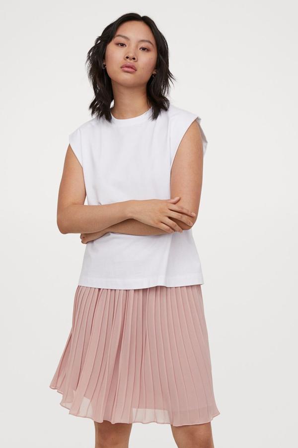 Disponible en rosa o en negro, esta falda corta en gasa plisada cuenta con talle alto con cintura elástica y forro de satén. Tiene un precio de 29,99 euros.