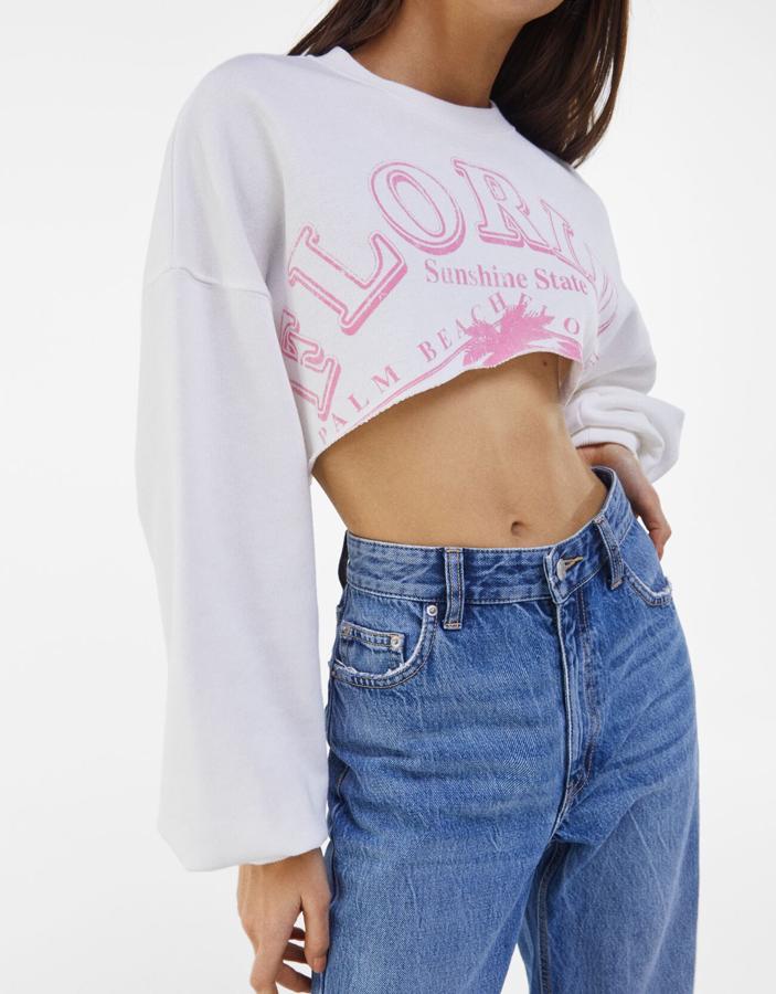 En Bershka hemos encontrado esta sudadera blanca con print a contraste en rosa con mangas largas y cuello redondo que tiene un precio de 15,99 euros y está disponible entre las tallas XS y XL.