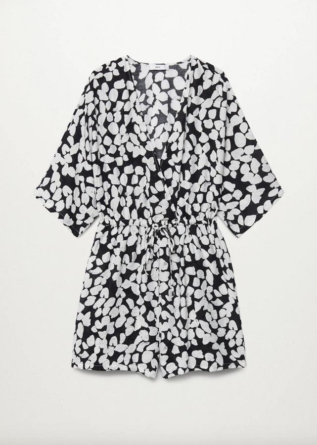 Tejido fluido con estampado blanco sobre fondo negro para este mono corto de Mango con escote de pico cruzado, mangas cortas acampanadas y cintura con cordón ajustable. Tiene un precio de 29,99 euros y está disponible entre las tallas XS y XL.