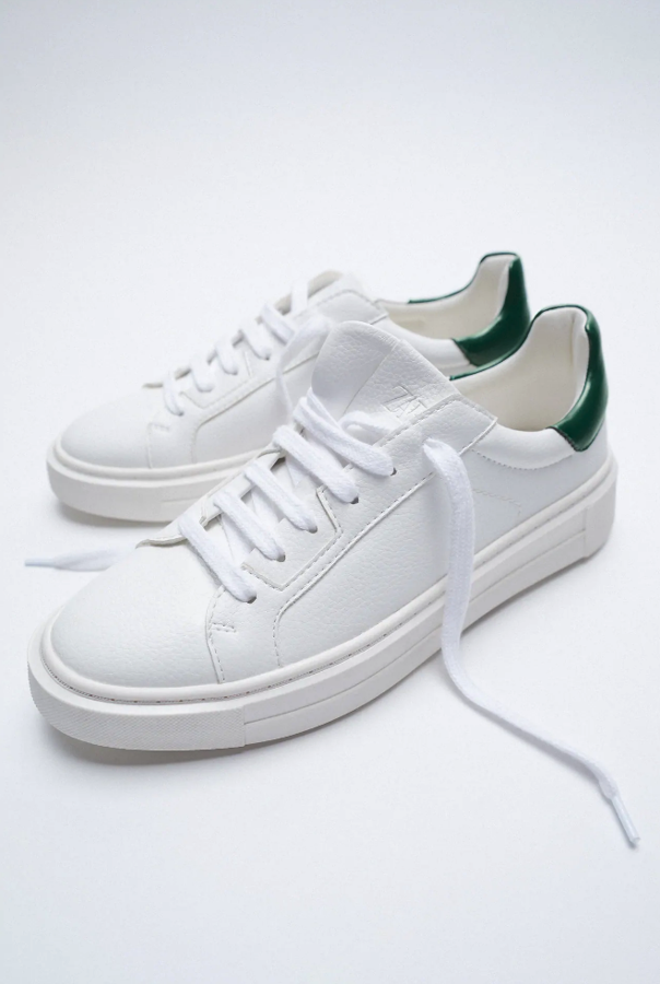 Un clásico que no pasa de moda son las zapatillas blancas y estas, con detalle en verde en el talón, cuestan 12.99 euros en los Special Prices de Zara.