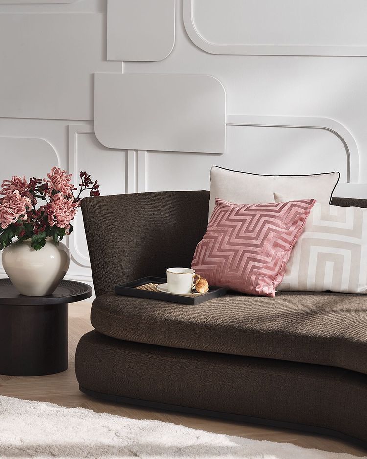 Los toques de color serán clave en la decoración de primavera de tu hogar. El cojín rosa con textura cuesta 14.99 euros en H&M Home, y el jarrón de porcelana, 39.99 euros.