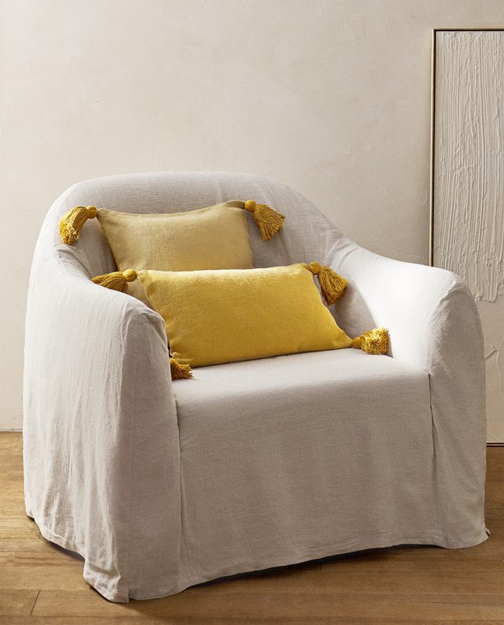 Disponible en varios colores y tamaños, esta funda de cojín con detalle de pompones en los extremos y cierre con cremallera tiene un precio rebajado de 15,99 euros.