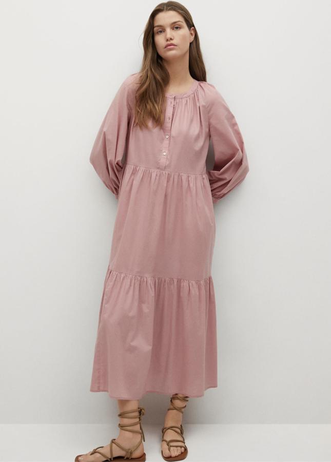 Disponible en rosa o en negro, este vestido camisero de corte midi y confeccionado en 100% algodón cuenta con manga larga abullonada y volantes. Tiene un precio de 39,99 euros.