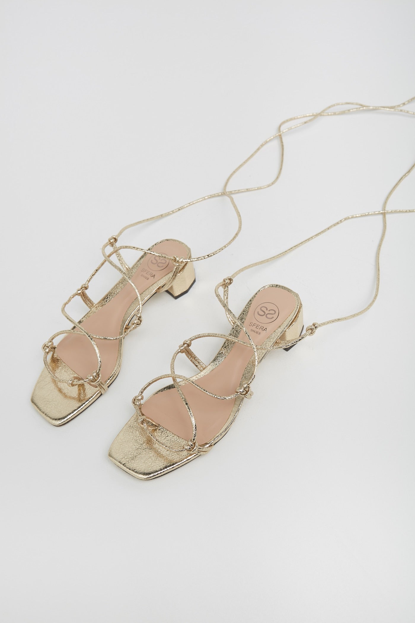 Sandalias atadas en color dorado con tacón sensato. El calzado cómodo que tus looks elegantes necesitan. (19,99 euros).